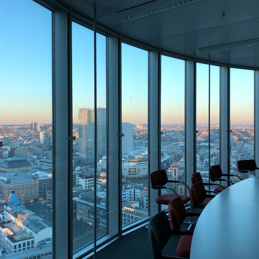 Odoo Community vs Enterprise - baie vitrée montrant une ville en contrebas au levé du soleil