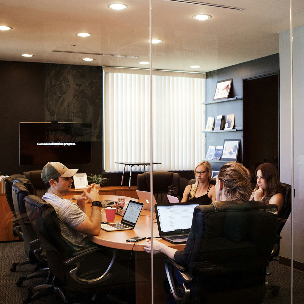 Odoo Community vs Enterprise - réunion de 4 personnes autour d'une table